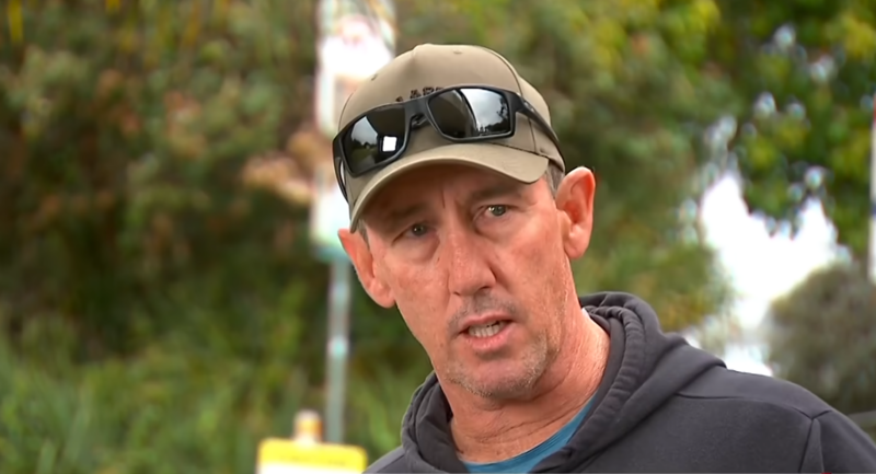 Il surfista Matthew Devine con un cappellino e gli occhiali da sole sulla visiera durante un'intervista