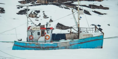 Peschereccio in un paesaggio polare innevato