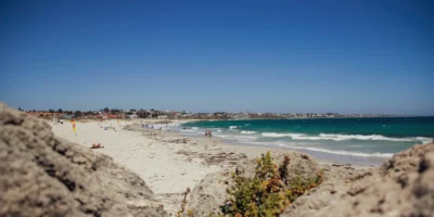 Bagnanti e onde a Sorrento Beach, con rocce in primo piano