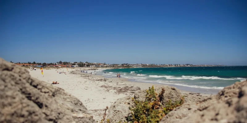 Bagnanti e onde a Sorrento Beach, con rocce in primo piano